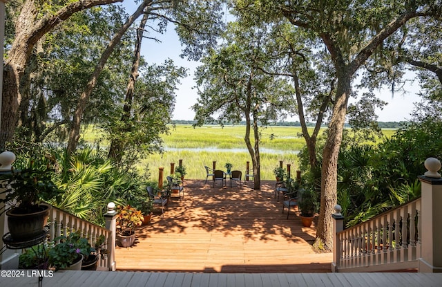 wooden deck with a water view and a rural view