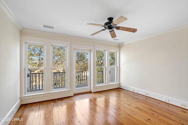 spare room featuring visible vents, baseboards, light wood-style flooring, ceiling fan, and ornamental molding