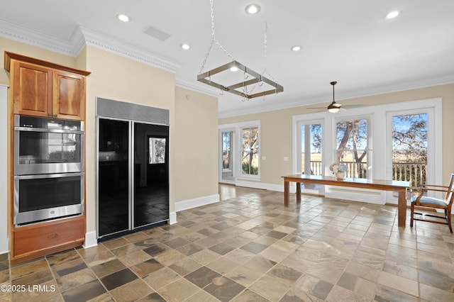 kitchen featuring high end black fridge, stainless steel double oven, and crown molding