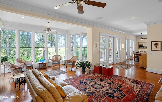 living room with ornamental molding, plenty of natural light, wood finished floors, and baseboards