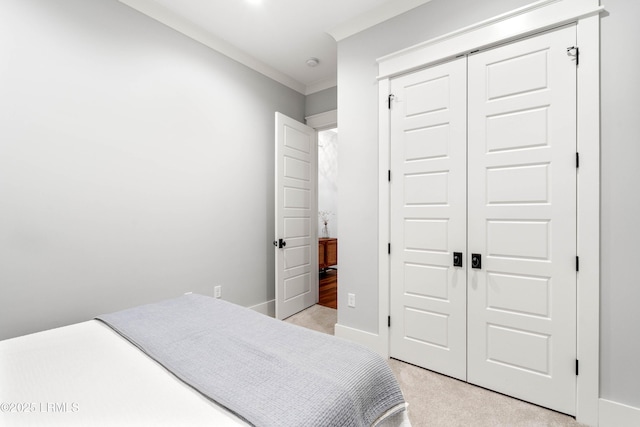 bedroom featuring ornamental molding, light carpet, and a closet