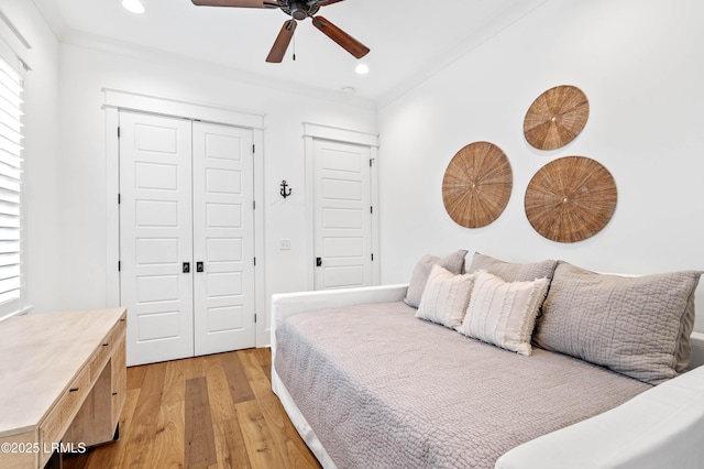 bedroom featuring ornamental molding, ceiling fan, and light hardwood / wood-style flooring