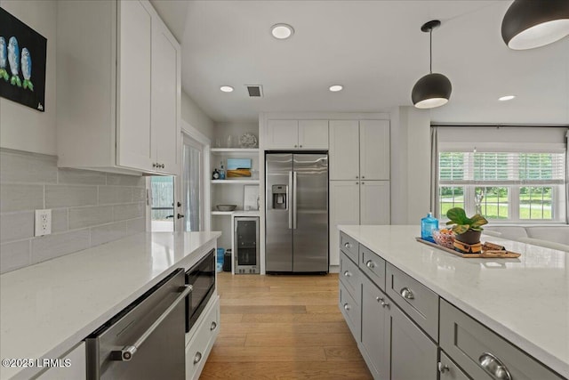 602 Huguenin Dr, Beaufort, SC 29902 - kitchen featuring stainless steel appliances, wine cooler, light wood-style floors, open shelves, and tasteful backsplash