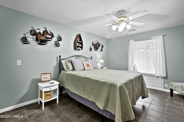bedroom featuring baseboards, a ceiling fan, a textured ceiling, and visible vents