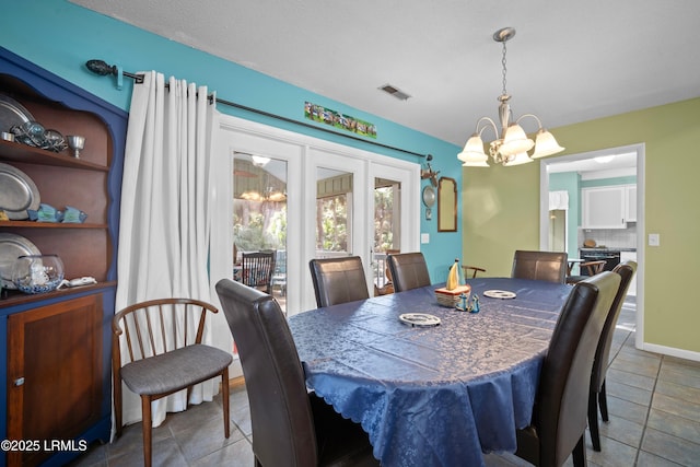 dining area with visible vents, tile patterned flooring, and an inviting chandelier