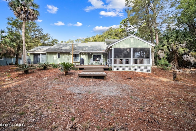 back of property with a sunroom and a deck