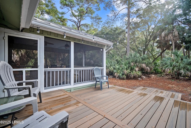 wooden deck featuring a ceiling fan and a sunroom