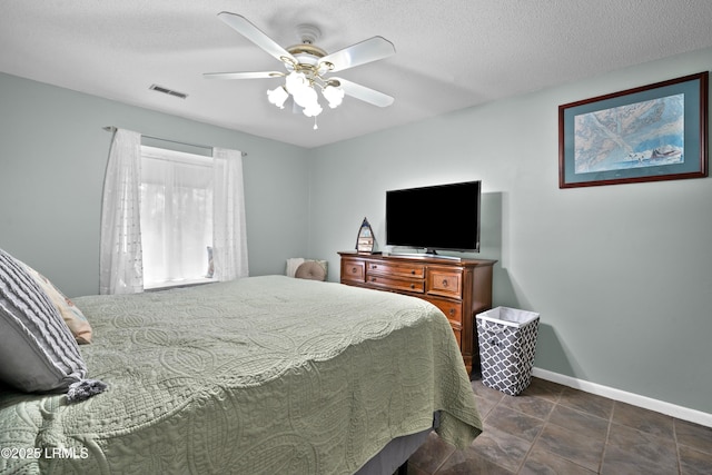 bedroom featuring a textured ceiling, visible vents, a ceiling fan, and baseboards