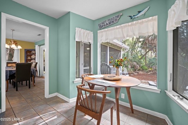 dining area with baseboards, a chandelier, and plenty of natural light