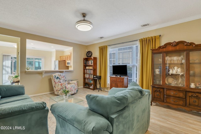 living room featuring ornamental molding, a textured ceiling, and light hardwood / wood-style floors