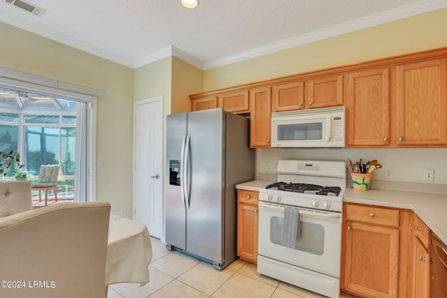 kitchen with crown molding, light tile patterned floors, a textured ceiling, and white appliances