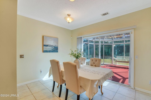 tiled dining area with crown molding and a textured ceiling