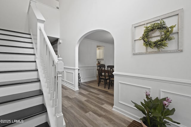 249 Hitching Post Cres, Bluffton, SC 29910 - entryway with arched walkways, wood finished floors, a wainscoted wall, stairway, and a decorative wall