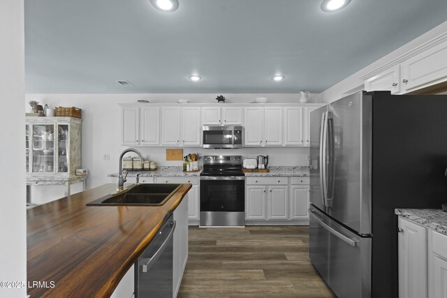 249 Hitching Post Cres, Bluffton, SC 29910 - kitchen featuring appliances with stainless steel finishes, a sink, butcher block countertops, white cabinets, and dark wood-style floors