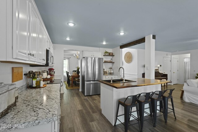 249 Hitching Post Cres, Bluffton, SC 29910 - kitchen with stainless steel appliances, a sink, white cabinetry, wooden counters, and a breakfast bar