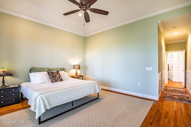 bedroom featuring hardwood / wood-style flooring, ceiling fan, and ornamental molding