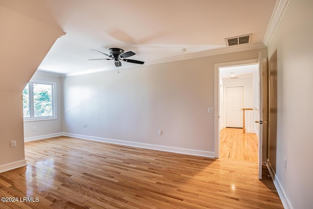 interior space with ceiling fan, ornamental molding, and light wood-type flooring