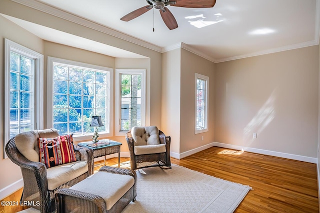 sitting room featuring hardwood / wood-style floors, crown molding, and ceiling fan