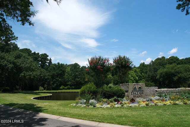 view of property's community with a yard and a water view