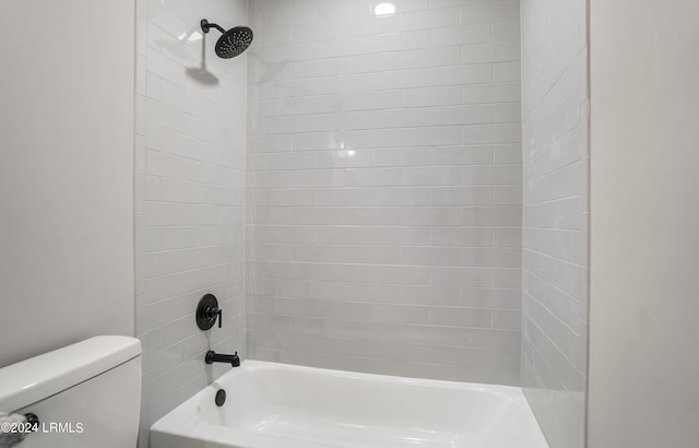 bathroom featuring tiled shower / bath combo and toilet