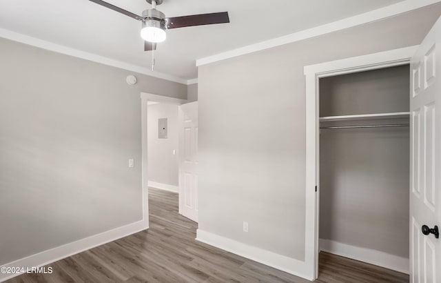 unfurnished bedroom featuring hardwood / wood-style flooring, ceiling fan, ornamental molding, and a closet