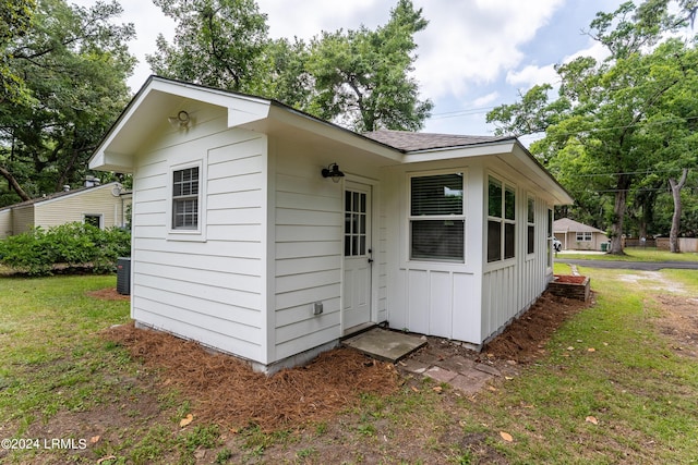 view of outbuilding with a yard and central AC unit