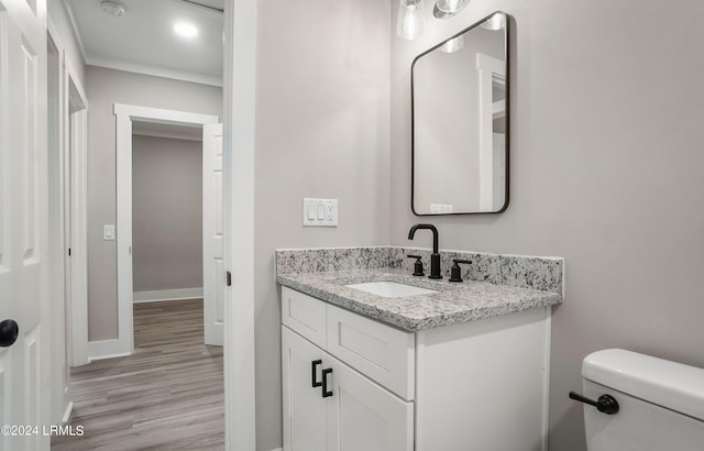 bathroom with hardwood / wood-style flooring, vanity, and toilet