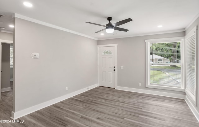 empty room with ornamental molding, dark wood-type flooring, and ceiling fan