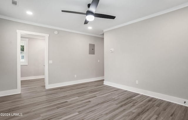 unfurnished room featuring ornamental molding, hardwood / wood-style floors, electric panel, and ceiling fan