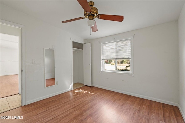 unfurnished bedroom featuring hardwood / wood-style flooring, ceiling fan, and a closet