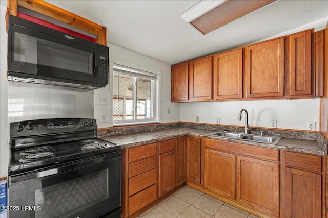 kitchen featuring light tile patterned floors, sink, and black appliances