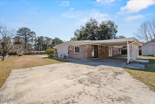 view of front of property featuring a storage shed, a front yard, and a carport