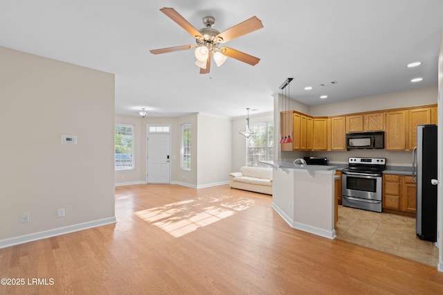 16 Maidencane St, Bluffton, SC 29910 - kitchen featuring stainless steel appliances, open floor plan, a peninsula, light wood-style floors, and a kitchen breakfast bar