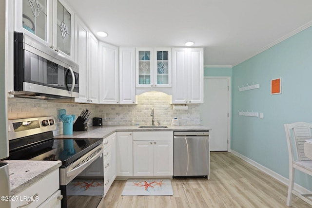 15 S Forest Beach Dr Unit 1D, Hilton Head Island, SC 29928 - kitchen featuring stainless steel appliances, a sink, decorative backsplash, light wood finished floors, and ornamental molding