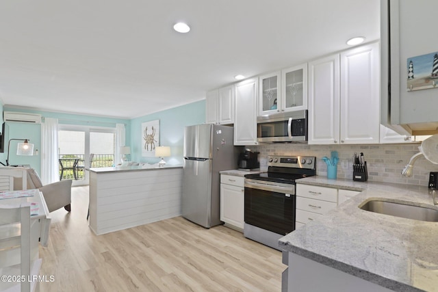 15 S Forest Beach Dr Unit 1D, Hilton Head Island, SC 29928 - kitchen with stainless steel appliances, a sink, white cabinetry, light stone counters, and tasteful backsplash