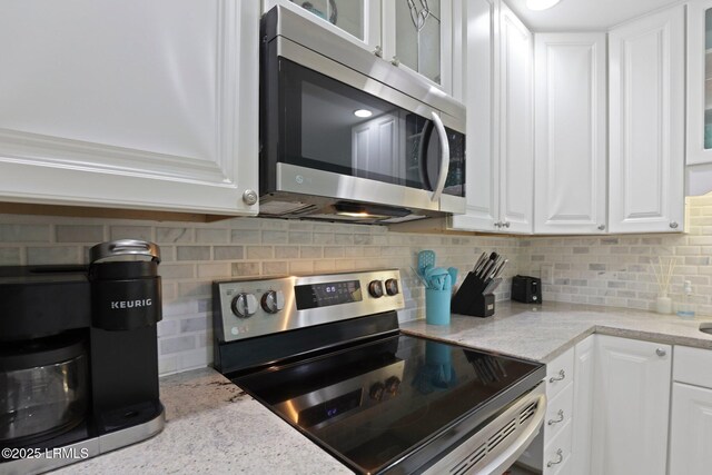 15 S Forest Beach Dr Unit 1D, Hilton Head Island, SC 29928 - kitchen featuring appliances with stainless steel finishes, white cabinetry, glass insert cabinets, and decorative backsplash