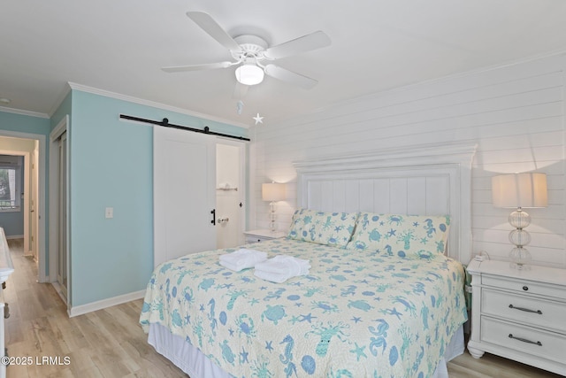 15 S Forest Beach Dr Unit 1D, Hilton Head Island, SC 29928 - bedroom with a barn door, ornamental molding, light wood-style floors, baseboards, and ceiling fan
