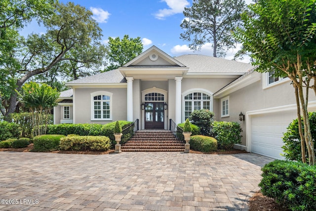 71 Peninsula Dr, Hilton Head Island, SC 29926 - neoclassical home with a garage, driveway, stucco siding, and roof with shingles