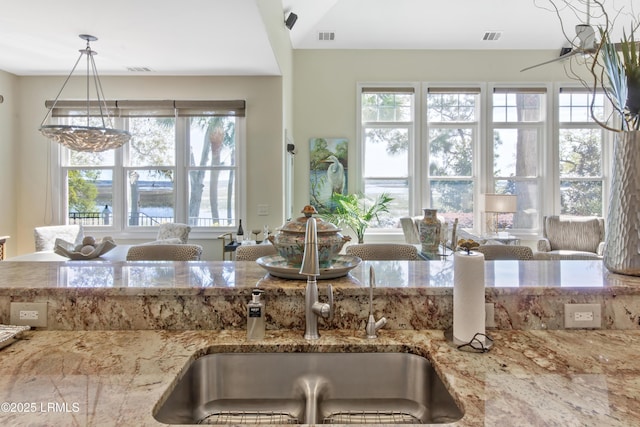 71 Peninsula Dr, Hilton Head Island, SC 29926 - kitchen with plenty of natural light, light stone counters, and a chandelier