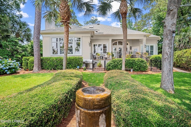 71 Peninsula Dr, Hilton Head Island, SC 29926 - view of front facade featuring stucco siding, a front lawn, and a shingled roof
