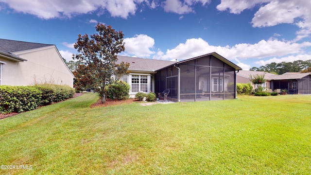 rear view of house with a yard and a sunroom