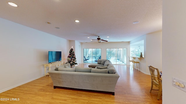 living room featuring ceiling fan and light hardwood / wood-style floors