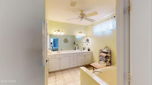 bathroom featuring a bathtub, tile patterned flooring, vanity, ceiling fan, and a textured ceiling