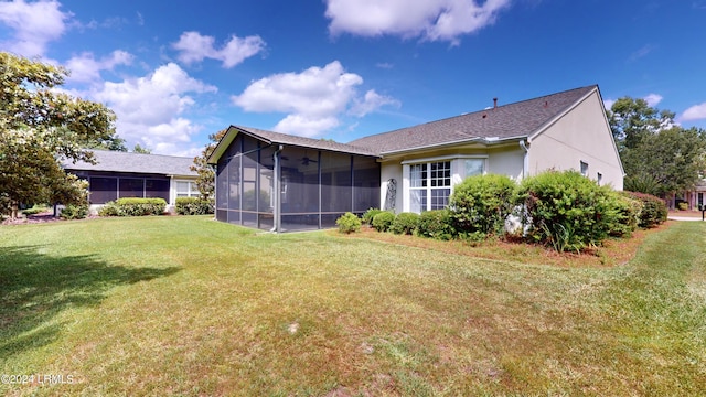 back of property featuring a sunroom and a lawn