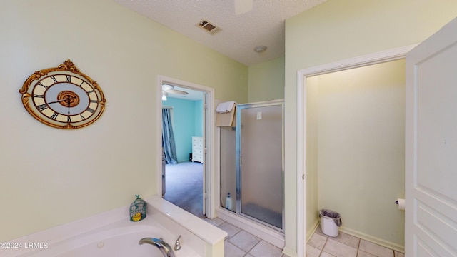 bathroom with ceiling fan, plus walk in shower, tile patterned flooring, and a textured ceiling