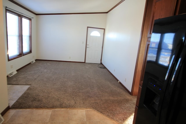 spare room with light tile floors and crown molding