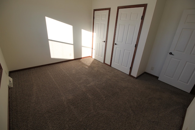 unfurnished bedroom with dark colored carpet