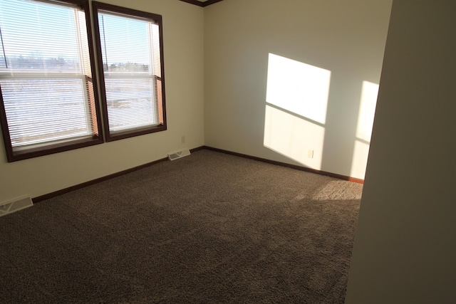 unfurnished room featuring dark colored carpet