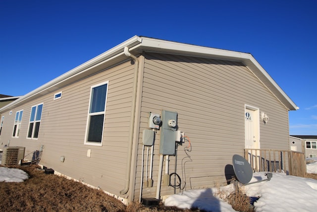 snow covered property with central AC