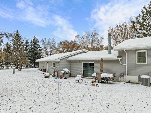 snow covered property featuring central AC unit